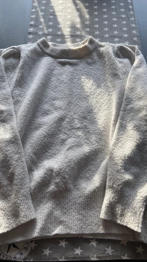 Stickad tröja  - Säljer min stickade tröja i fin krämvit färg, jättefin med detaljer på axlarna. Den är inte riktigt stickat material men någonting där om kring därför är den inte heller stickig som sånna tröjor kan vara. 