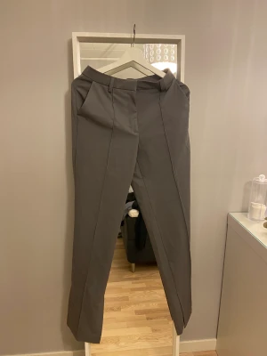 Kostymbyxor  - Skit snygga gråa kostymbyxor knappt använda säljer pga att dem är för stora för mig jag är 165 och storleken är 34 men dem är lite för långa.