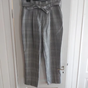 Rutiga kostymbyxor - Rutiga kostymbyxor i mycket gott skick. Lite mom-jeans fit med knytning i midjan och raka ben. Lite små i storleken. 
