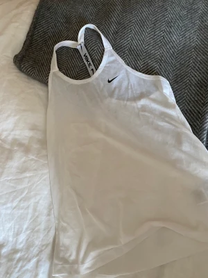 Nike träningslinne öppen rygg  - Jättefint och luftigt teäningslinne från Nike, öppet i ryggen perfekt att träna i på sommarn. Använt ett fåtal gånger! Hör av dig vid funderingar, kram Ebba