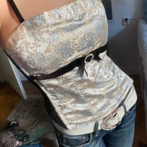 Korsett - Suuperfin guldig och silvrig korsett med svart när på sidorna 