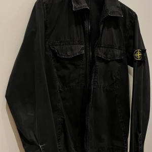Stone island overshirt - Rensning i garderoben och säljer av min Stone Island overshirt i tvättad svart färg.  Har en lagning i höger armhåla, inlämnad till skräddare som lagat(se bild). Inget som syns alls när man använder jackan.  Storlek small  Hojta om de är några frågor. 