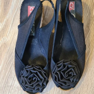 Klackskor - Svarta somriga klackskor i str 35 med en ros vid tårna