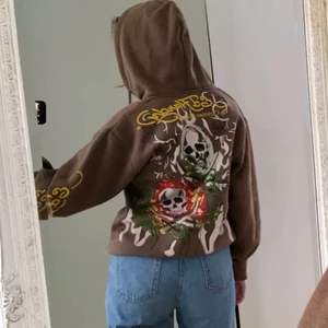Ed Hardy Brun hoodie - Säljer min hoodie eftersom jag inte använder den lika mycket längre och har brist på pengar :,) den är verkligen hur fin som helst och sjukt bra tjock kvalite. Rhinestones på trycket på ryggen, syns inte så bra på bilden ❤️ Äkta såklart. K