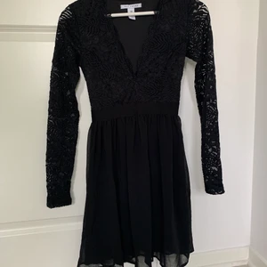 Svart klänning  - En v-ringad långärmad spetsklänning i storlek xs, men passar även s. Från Nelly, använd endast en gång! Hör av er vid frågor. Se gärna mina andra annonser:)