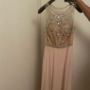 Ljusrosa klänning - En fin och lyxig lång klänning i en ljusrosa färg. Fina diamanter och stenar fastsydda både fram och bak. Använd 1 gång och är i storlek XS. Köpt för 3200kr, säljes för 1500kr. (Pris går att diskutera)👑