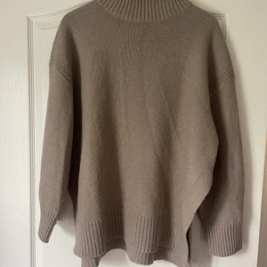 Beige stickad tröja  - Lång beige stickad tröja med slits 