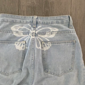 Blå jeans - Superfina blå jeans med en vit fjäril bak på, de är raka i modellen och lite baggy! Strl xs men passar mer som en S🤍
