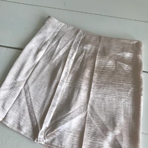 Kjol  - Kjol ifrån Gina tricot glasigt material i beige guld färg fint skick stl 36