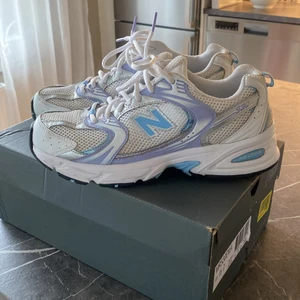 New Balance 530 - Snyggaste skorna som är slutsålda överallt. New Balance MR530. Använda ett fåtal gånger. Vita med lila och blå detaljer. Storlek 8,5 (42). 
