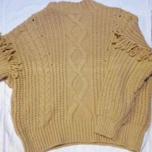 Stickad tjocktröja  - Stickad tjocktröja i mustard färg med fina detaljer, perfekt till vintern då den håller riktigt varmt! Färgen syns bäst på 1:a och 2:a bilden. Använt 1-2 gånger. Oversized passar S-L. 