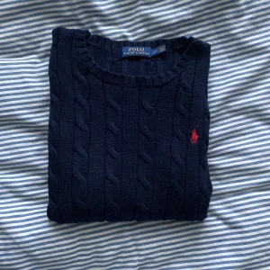 Stickad tröja från Ralph Lauren i storlek XS/S - En väldigt fin, marinblå, stickad tröja från Polo Ralph Lauren i storlek XS / S. Sparsamt använd och därav i fint skick. (samfraktar gärna)