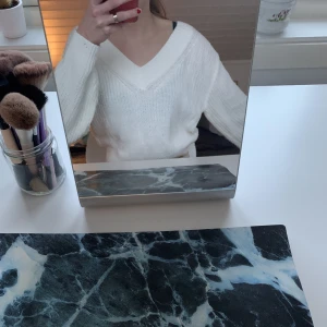 Vit stickad tröja - En jättefin V-ringad croppad stickad tröja från H&M. Tröjan är i mycket bra skick och endast använd ett fåtal gånger!