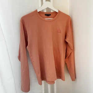 Rosa Acne långärmad - En långärmad t-shirt från Acne. Använd 2 gånger. Tydligen ett litet hål vid armen som jag precis upptäckte, syns ej, därav det låga priset. Annars helt som nytt. Färgen är mer slm sista bilden!!