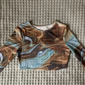 Mönstrad croptop  - Cool långärmad croptop i brunt/blått swirlmönster🤎💙 Aldrig använd så i nyskick!