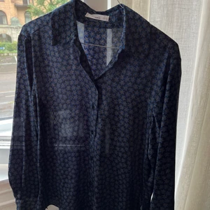 Byxa + blus set MANGO - Ett super fint set i satin med ett par byxor och en blus i marinblå färg med små mönster i tyget.   Aldrig använt. Kan användas både till vardag och som fint pyjamas set hemma:) storlek xs men funkar till en s också! 