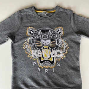 Kenzo tröja  - En Kenzo tröja i storlek S för dam. Tröjan är endast använd ett fåtal gånger och är därför i bra skick! Det finns en ytterst liten defekt på magen som ej syns. Tröjan finns inte längre tillgänglig i Kenzos sortiment och är köpt för ordinarie pris 1800kr.  Hör gärna av dig vid intresse