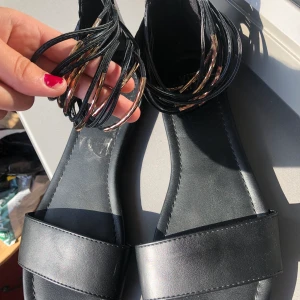 Sandaler - Svarta sandaler med brons/guld band som blir som flera fotband när man har på sig dom. Skitsnygga, bra skick!💋 