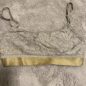 Bh topp  i färgen grå  - En bh/topp i färgen grå och silver, med band uppe vid axeln. 