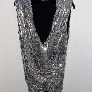 Paljett klänning - Jättefin klänning från Zara, Axelvaddar och snygg urringning vilket ger lite lyxigare stil. Sitter lite ”kavaj” upptill och tajtare runt midjan.  Använd 1/2 kväll så den är som ny!   Sitter jättefint! Fler bilder vid intresse.  Strl S men mer som en M. 