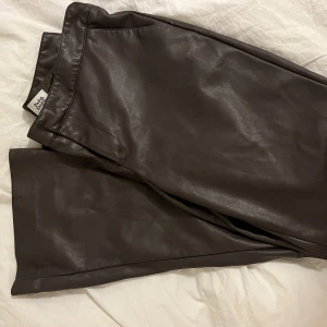 Mörkbruna skinnbyxor - Mörkbruna skinnbyxor i kickflare modell från twist and tango. Knappt använda!
