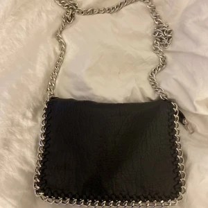 Väska  - En svart axelväska som inte längre används. Den är lite rostig i knappen men magneten funkar fortfarande🖤