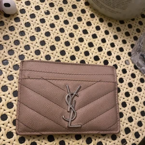 Ysl plånbok  - Säljer denna jättefina plånbok från Saint Laurent. I använt skick men inget man tänker på. Köpt för 2700 därav priset