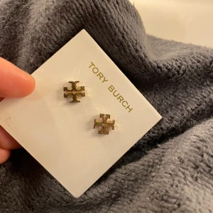 Tory burch - Örhängen från tory burch i guld. Extremt snygga passar till allt. Använt skick. Har ej original pluppar till dom. Nypris 1000kr. Jag säljer för 350kr +frakt vid snabb affär