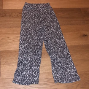 Blom Byxor - Svarta byxor med vita blommor på