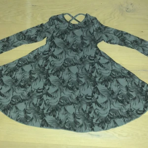 Grå mönstring klänning storlek 14 - Grå mönstring klänning med kors där bak. Inkluderar ej frakt eller Swish. Tar Swish