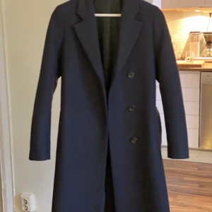 Caya coat - Filippa K - Kaya coat från Filippa K köpt höst 2021 Storlek: 32 Färg: Navy Säljes pga köpte fel storlek. Använd 1 gång.
