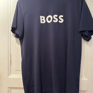 Hugo boss - Hugo boss T-shirt storlek L men passar även dig som bär M  Det är deras nya logga.  Den är i mycket gott skick  Hämtas i Eskilstuna eller skickas mot att köpare står för frakten 