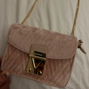 Valentino väska - En rosa valentino handväska i sammet. Extremt bra skick och använt väldigt sparsamt. Max 5 gånger. Perfekt till både stan och klubben!!! Väldigt gullig!!!