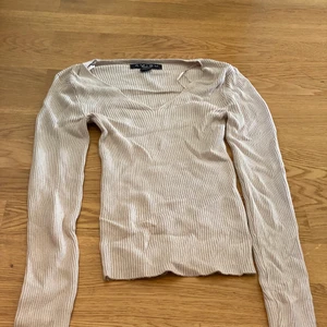 Beige långärmad tröja från AMISU Stl XS - Beige långärmad tröja från AMISU, Stl XS. Lågt urringad, fint skick. Köpare står för 51 kr frakt 