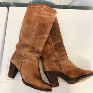 Varmfodrade skinnstövlar strl 39/40 - Härliga skinnstövlar från finska Noora.  10 cm klack.  Robust tålig stövel med god sula som inte glider på snö och is.  Äkta skinn.  Med varm fluffig insida för kallt klimat.   Helt oanvända.  