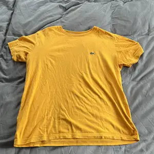 Säljer denna gula och fina t-shirt från Lacoste i stolek 164/XS