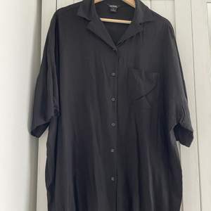 oversizee black shirt from Monki. 3/4 sleeves, cheast pocket and buttons at the front.