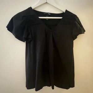 Svart blus  - Svar liten blus som man kan styla på olika sätt. Den är i ett bra skick!