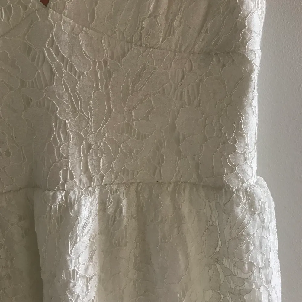 Säljer nu denna vita klänning med spets från Nelly i strl 34! Endast använd en gång, därav fortfarande i väldigt bra skick. Sitter superfint på, perfekt till studenten eller andra sommaraktiviteter. Dragkedja på baksidan. Köparen står för frakten❤️☺️. Klänningar.