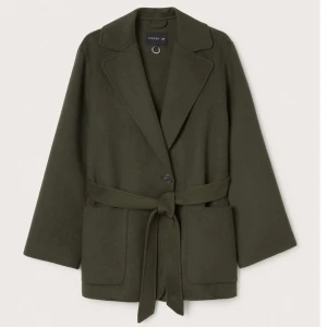 Kappa kort - Säljer denna supersnygga kappa i mörkgrön från Stockholm LM. Nypris 1500kr säljer för 700kr. Möts upp i Stockholm 💗