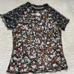 Nike topp - En meshtopp från Nike i blommigt mönster. I mycket fint skick, stl xs/s.