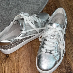 MK skor - Äkta Michael kors skor i silver/glittriga storlek 37, endast använda en gång ordinarie pris 1600kr mitt pris 1300kr