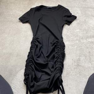 Det är en svart klänning som går att skjustera längden på super bra och skön på sommaren 