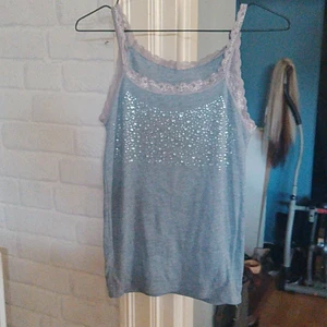 Glittriga top - Grå topp i basic linne ribbtyg med glitter stenar på. Använd en gång 