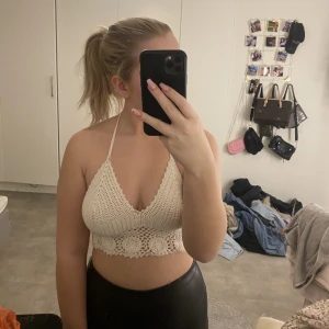 Stickad topp - En jättesnygg handgjord vit stickad topp med öppen rygg och "knyten". Köpt i Grekland och aldrig använd då den är lite liten enligt mig.