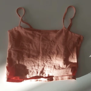 Croppad top - Croppad sommar-top. Andvänt typ 3 ggr. Bra skick. Ett extra tyg på insidan så man inte ser kanten på bh eller topp.Lite mer apricos än beige.