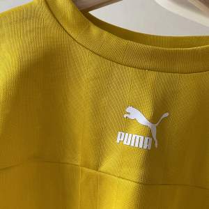 Gul t-shirt med lite längre ärmar. Tjockt, glansigt material. Märket Puma. Mycket fint skick! 