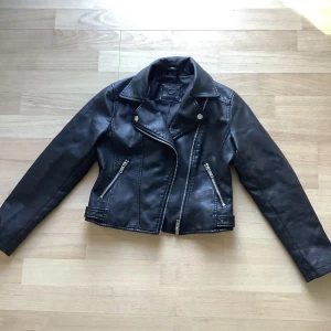 Skinnjacka  - En svart skinnjacka i storleken 152, den går att stänga med dragkedja. Superfin skinnjacka i fint skick.