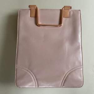 -Pink Leather -Blue Lining -Metallic Hardware with Embossed Branding -Comes with Leather Shoulder Strap and Metal Handles for Versatile Wear -Snap Closure -2 Bag Compartments that can hold MacBook -2 phone pockets -2zip pockets  Shows some signs of wear