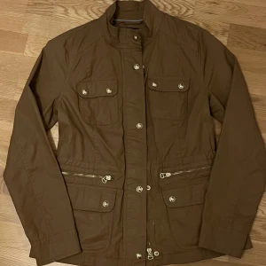 Brun jacka från Tommy Hilfiger - Använd ett fåtal gånger. Normal i storleken och går att spänna åt i midjan. 